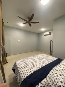 a bedroom with a ceiling fan and a bed at Untung5tay in Gua Sai