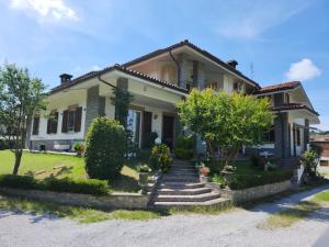 a white house with stairs in front of it at Casa vacanza Nada in Dogliani