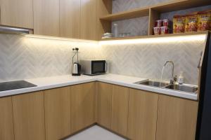 a kitchen with a sink and a microwave at Lovela Villa Phan Thiết in Ấp Bình Hưng