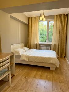 Un dormitorio con dos camas y una ventana en Сердце Арбата, en Almaty