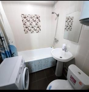 a bathroom with a white toilet and a sink at Назарбаева 19А уютная квартира в центре смарт тв wi-fi in Karagandy