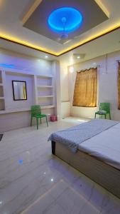a bedroom with a bed and two green chairs at Dwarika Palace in Mathura +13 photos