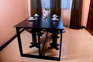 a black table with dishes on it in a room at Nestova Hostel in Nkunjila +19 photos
