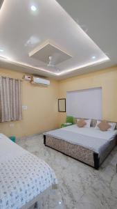 a bedroom with two beds in a room at Dwarika Palace in Mathura