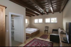 a bedroom with a bed and a chair in a room at Aurora Panzió in Bük