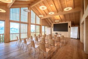 a conference room with a table and chairs and a screen at Berglodge37 in Altdorf