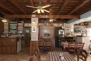a restaurant with a fireplace and tables and chairs at Aurora Panzió in Bük