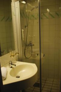a bathroom with a sink and a glass shower at Kumla Hotel in Kumla
