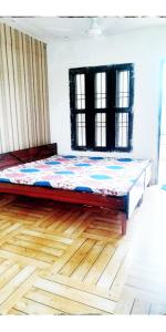 a large bed in a room with a wooden floor at Holy Hills Homestay in Zirakpur