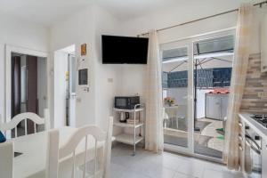 a living room with a flat screen tv on the wall at CASA VERDE Inn in Ischia