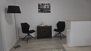 a room with two chairs and a table and a lamp at 2 Zimmer Ferienwohnung mit Terrasse in Ehlscheid +2 photos