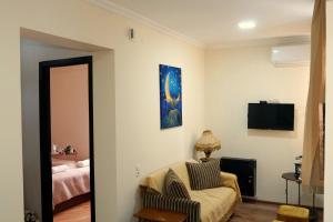 a living room with a chair and a bed at Luna in Kutaisi