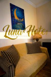 a couch in a living room with a sign on the wall at Luna in Kutaisi
