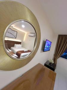 a bedroom with a large circular mirror in a room at Hotel Istanaku , Ipoh, Perak in Ipoh