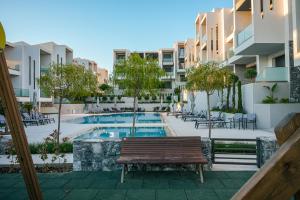 an apartment patio with a pool and a bench at Artion Suites Nikiti in Nikiti