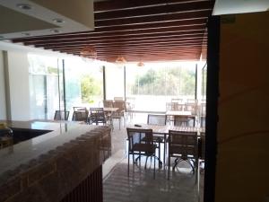 una sala da pranzo con tavoli, sedie e finestre di METTE Otel a Silifke