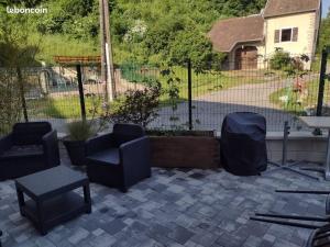 un patio con sedie, un tavolo e una recinzione di Gite des Campenottes a Longevelle-sur-Doubs