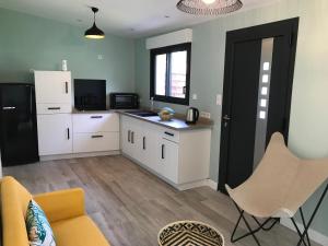 a kitchen with white cabinets and a black door at Coté Dune in Le Crotoy