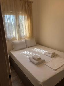 een slaapkamer met een bed met twee handdoeken erop bij Michalis Home in Nea Kalikratia +14 foto's