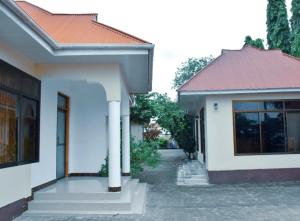 a white house with a red roof at Colobus View Lodge in Bagamoyo