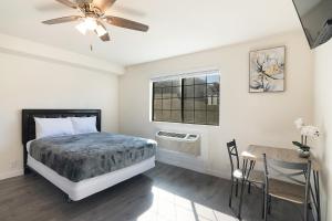 Un dormitorio con una cama y una mesa y una ventana. en LA Royal Viking Apartments, en Los Ángeles