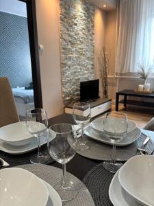 a table with plates and wine glasses on it at Balian apartman in Siófok