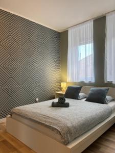 a bedroom with a large bed and a wall at Balian apartman in Siófok