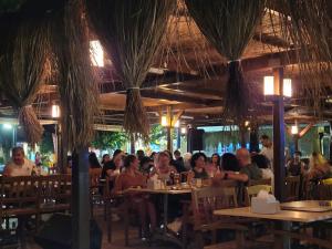 a group of people sitting at tables in a restaurant at Yağcı Hotel Erdek in Erdek