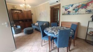 a dining room with a table and blue chairs at Casa Caterina in Cisano Bergamasco