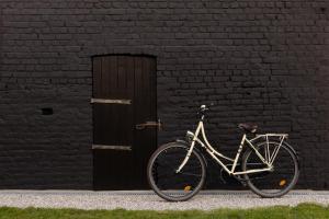 a bike parked in front of a black brick wall at La Maison Du Meunier in Dannes