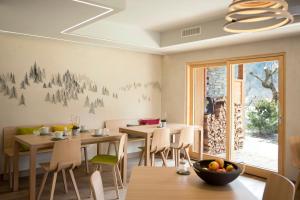 une salle à manger avec des tables et des chaises ainsi qu'une fenêtre dans l'établissement A Larze, au Châble