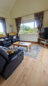 a living room with a couch and a coffee table at High Meadow House in Duncormick