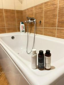 a bathroom sink with three bottles sitting on it at Apartment City kvart in Podgorica