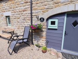ein lila Garagentor mit einem Stuhl und Blumen in der Unterkunft Wayside Farm Stable Cottage in Scarborough