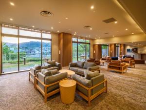 a lobby with couches and chairs and a large window at KAMENOI HOTEL Ome in Ome