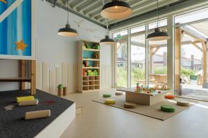 a childrens room with a table and a play area at Duinresort Dunimar in Noordwijkerhout