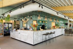 a woman sitting at a counter in a restaurant at Duinresort Dunimar in Noordwijkerhout