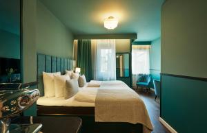 a hotel room with a large bed with white pillows at WIDE Hotel in Copenhagen