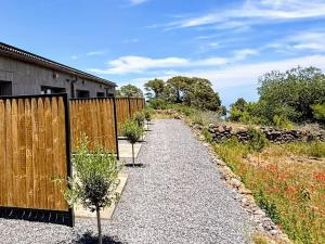 a gravel path next to a wooden fence at V.V. Verde Amanecer 5 in Las Casas