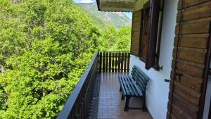 a bench sitting on the balcony of a house at Casa Gatto in Auronzo di Cadore