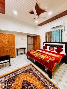 a bedroom with a bed with a red comforter at Vasantviharinn 500 meter from ram mandir in Ayodhya