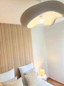 1 dormitorio con cama y lámpara de techo en Les Nuits d'Embalens, en Castelnau-dʼEstrétefonds