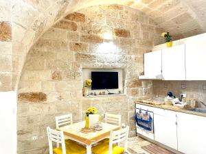 a kitchen with a table and a stone wall at Antica Pietra in Polignano a Mare