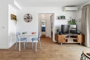 a living room with a table and chairs and a television at Flower Beach Suite 16 in Playa Honda