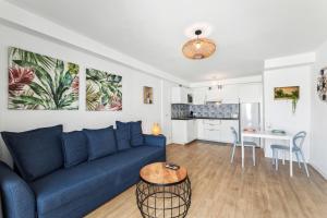 a living room with a blue couch and a kitchen at Flower Beach Suite 16 in Playa Honda
