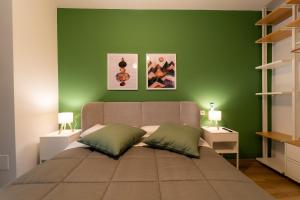a green bedroom with a large bed with two pillows at Design a 2 passi dal mare in Alba Adriatica