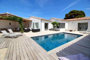 a house with a swimming pool and a wooden deck at MIA in La Noue