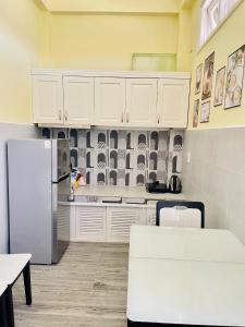 a kitchen with white cabinets and a refrigerator at Homestay Om Mer, Mindfullness in Da Lat