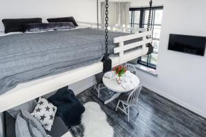 Un dormitorio con una cama grande y una mesa y sillas. en Elite Apartments Ogarna Suites Old Town, en Gdansk