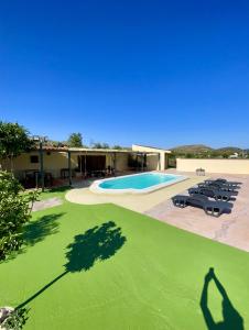 ベレス・ブランコにあるCortijo Albaのプールと椅子付きの家の景色を望めます。